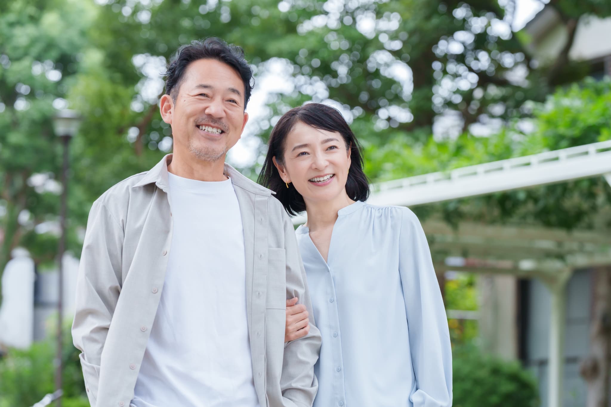 笑顔で腕を組んで歩く夫婦