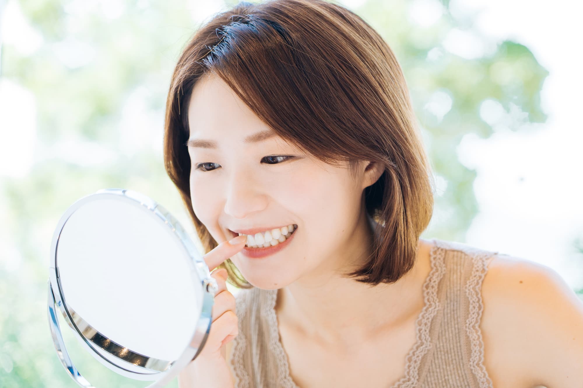 治療した歯を鏡で確認して嬉しそうな女性