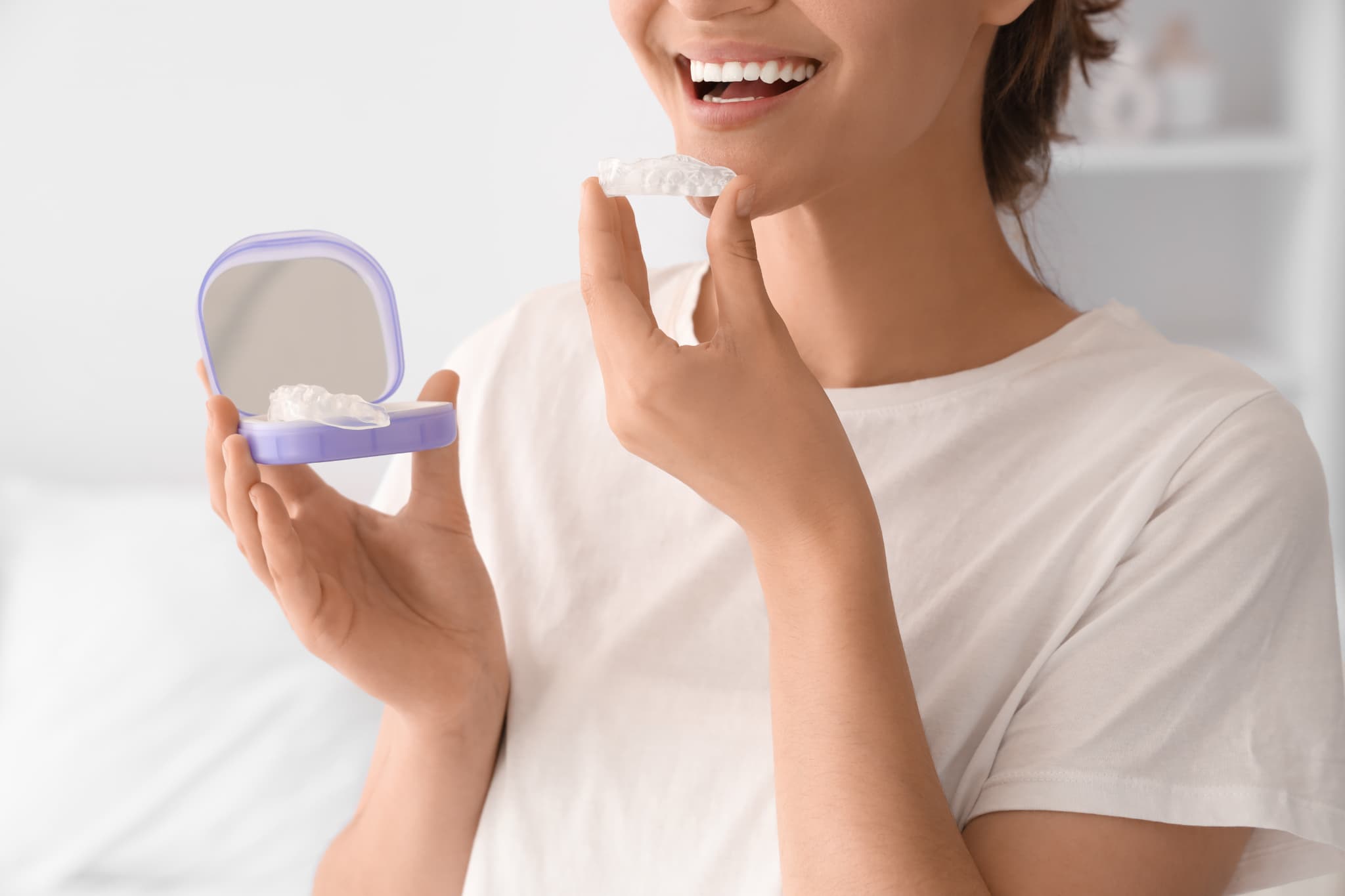 歯ぎしり・食いしばりの予防のためマウスピースを装着する女性
