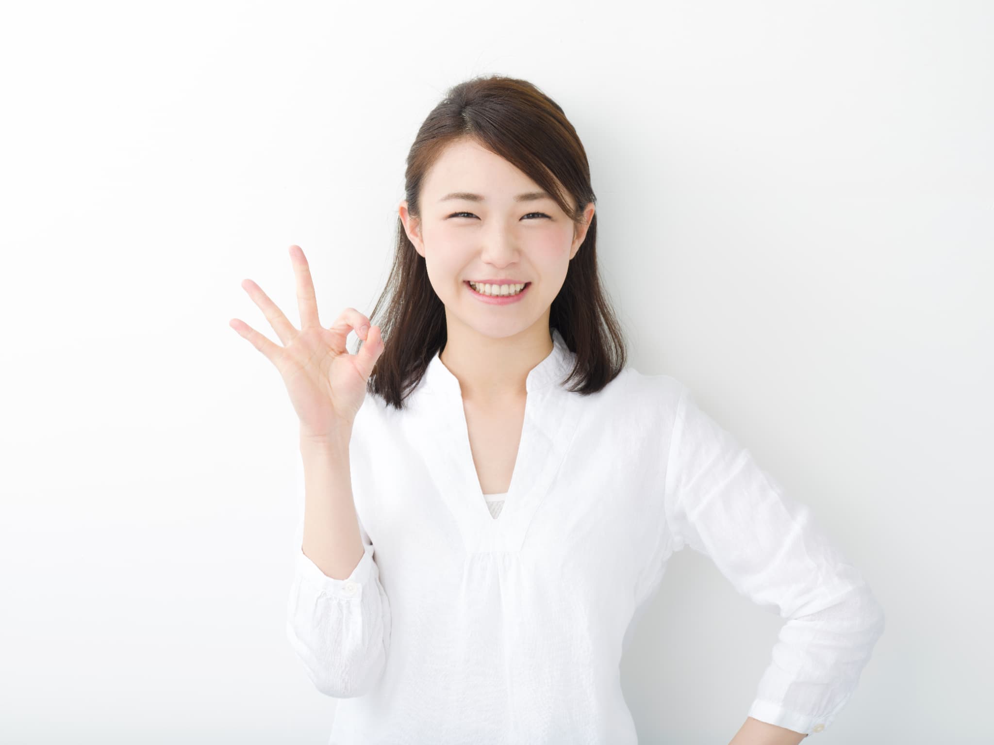 指でOKサインを出す女性
