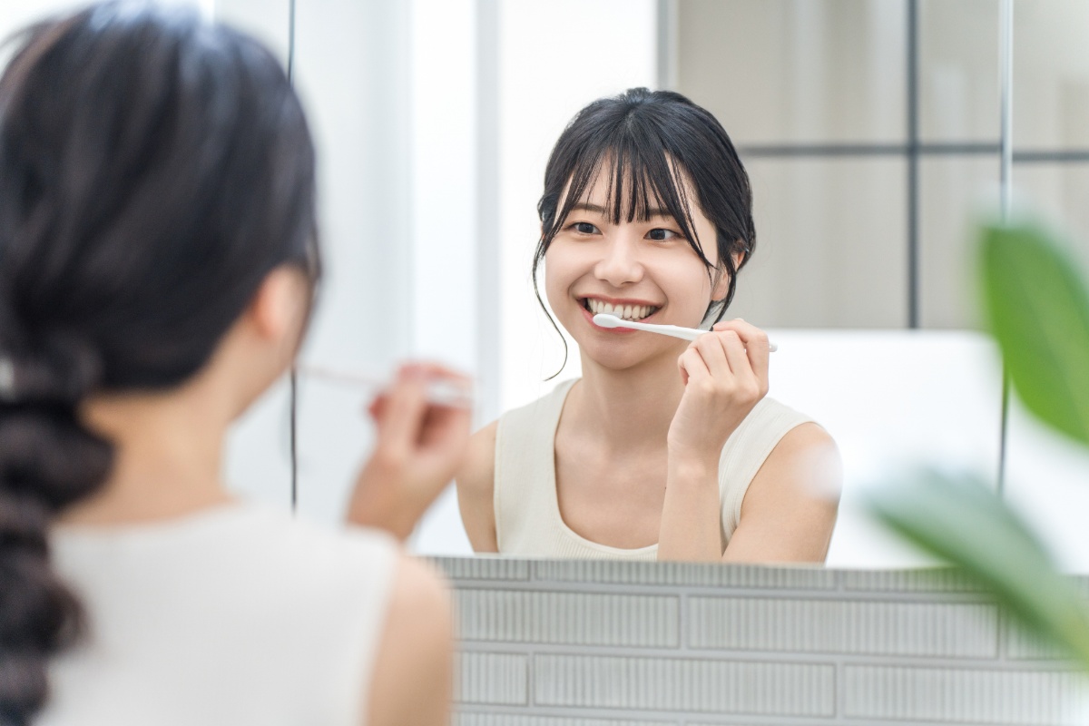 鏡を見ながらしっかりと歯みがきをする女性